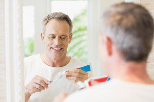 Handsome man brushing his teeth